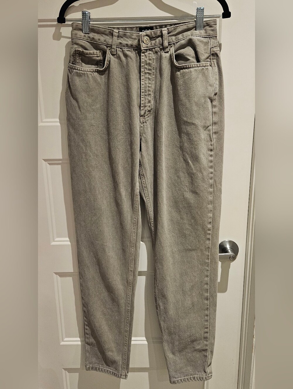 BDG Mom Jeans in a light taupe or beige color, featuring a high rise and a taper